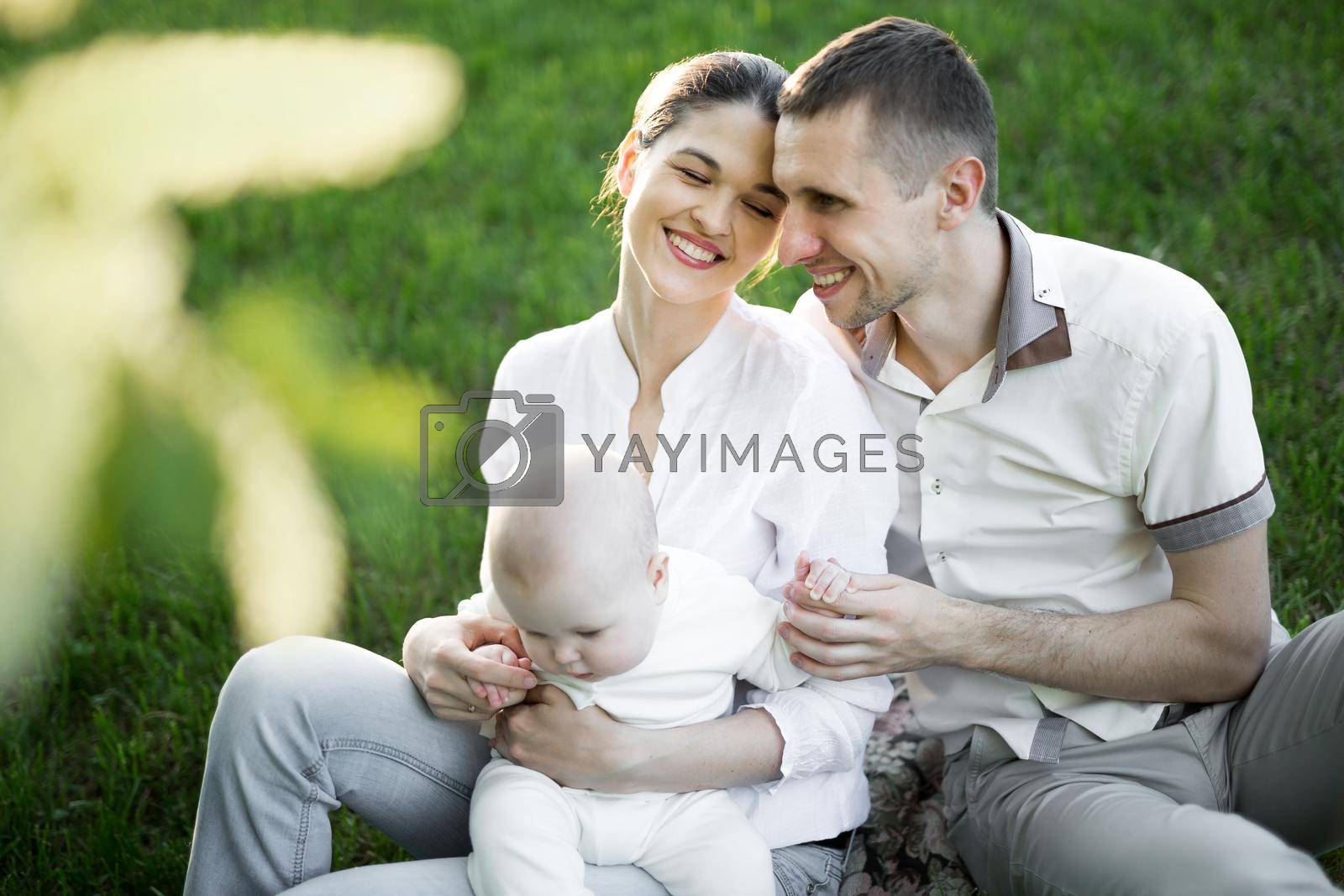 Portrait Beautiful Mother, Father And Baby outdoors. Happy family on a summer meadow