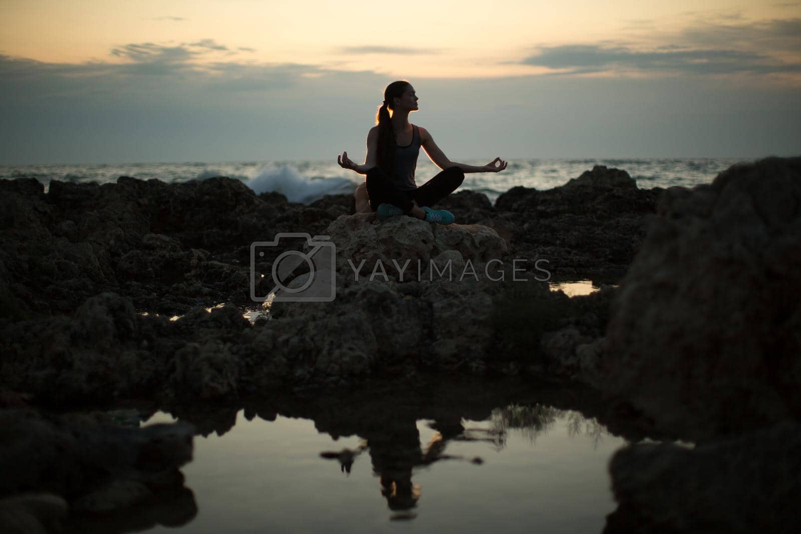 Royalty free image of Caucasian woman practicing yoga at seashore of ocean. by StudioPeace