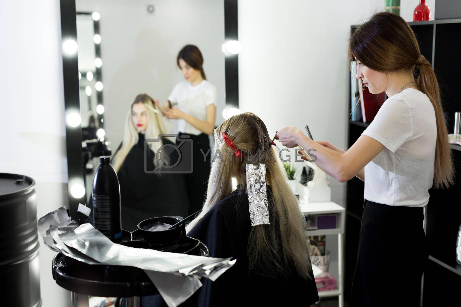 Blonde woman dying her hair at the beauty salon