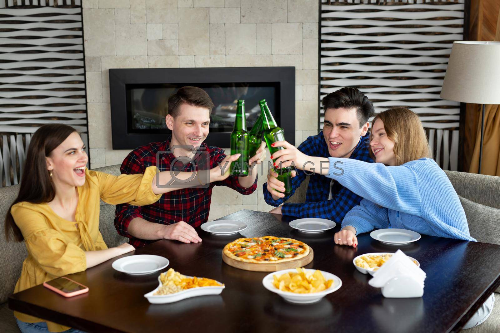 Group of young friends with pizza and bottles of drink celebrating
