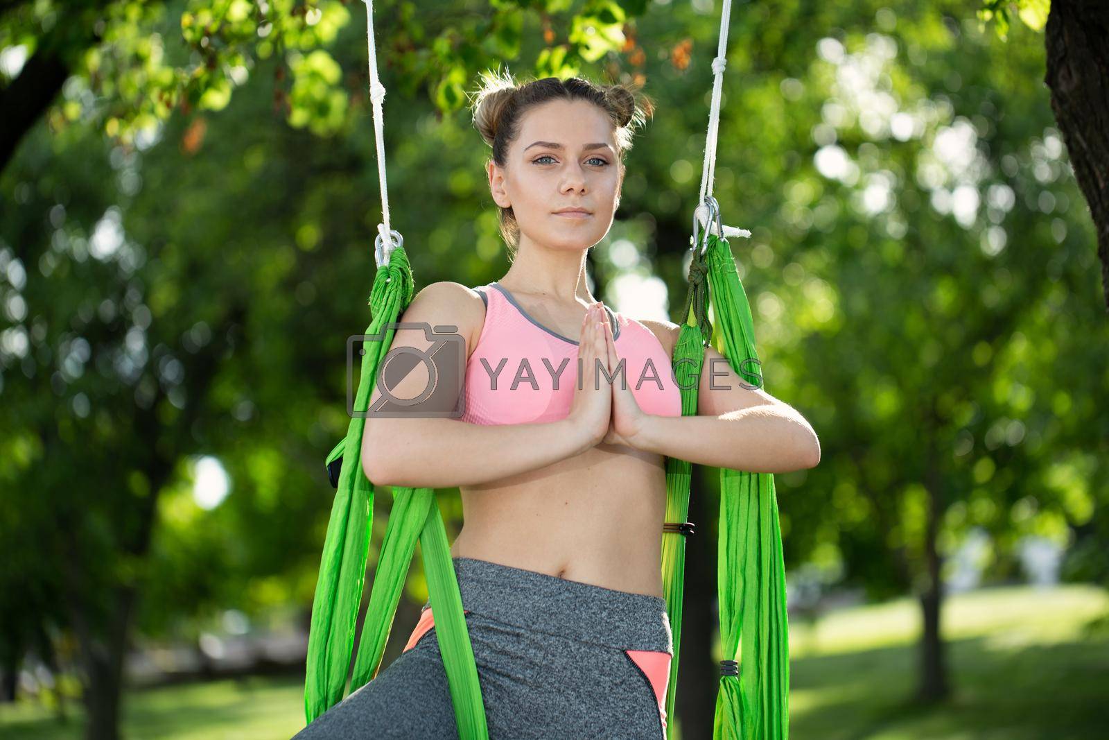 Anti-gravity Yoga, woman doing yoga exercises in the park
