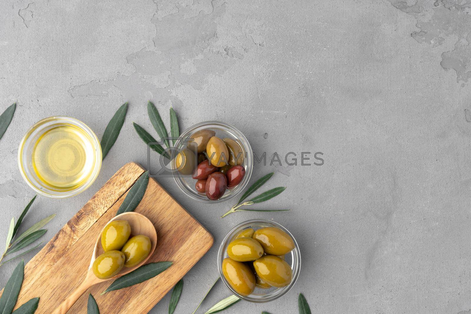 Royalty free image of Flatlay composition of olives and olive oil on gray background by Fabrikasimf