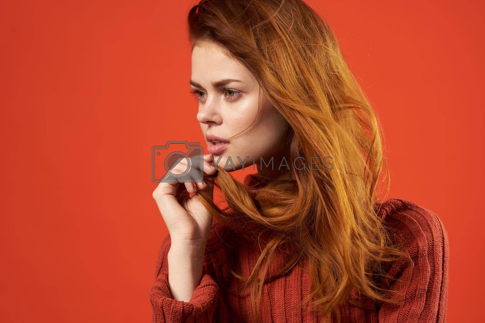 red-haired woman in red sweater fashion studio posing. High quality photo