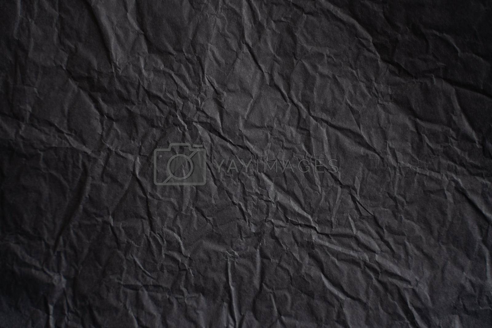 an empty wrinkled dark black tissue paper textured background