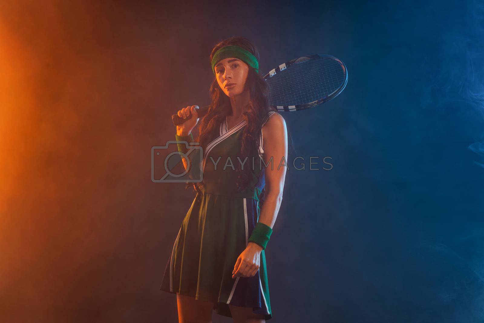 Royalty free image of Tennis player with racket in sportswear. Woman athlete playing dark background. by MikeOrlov