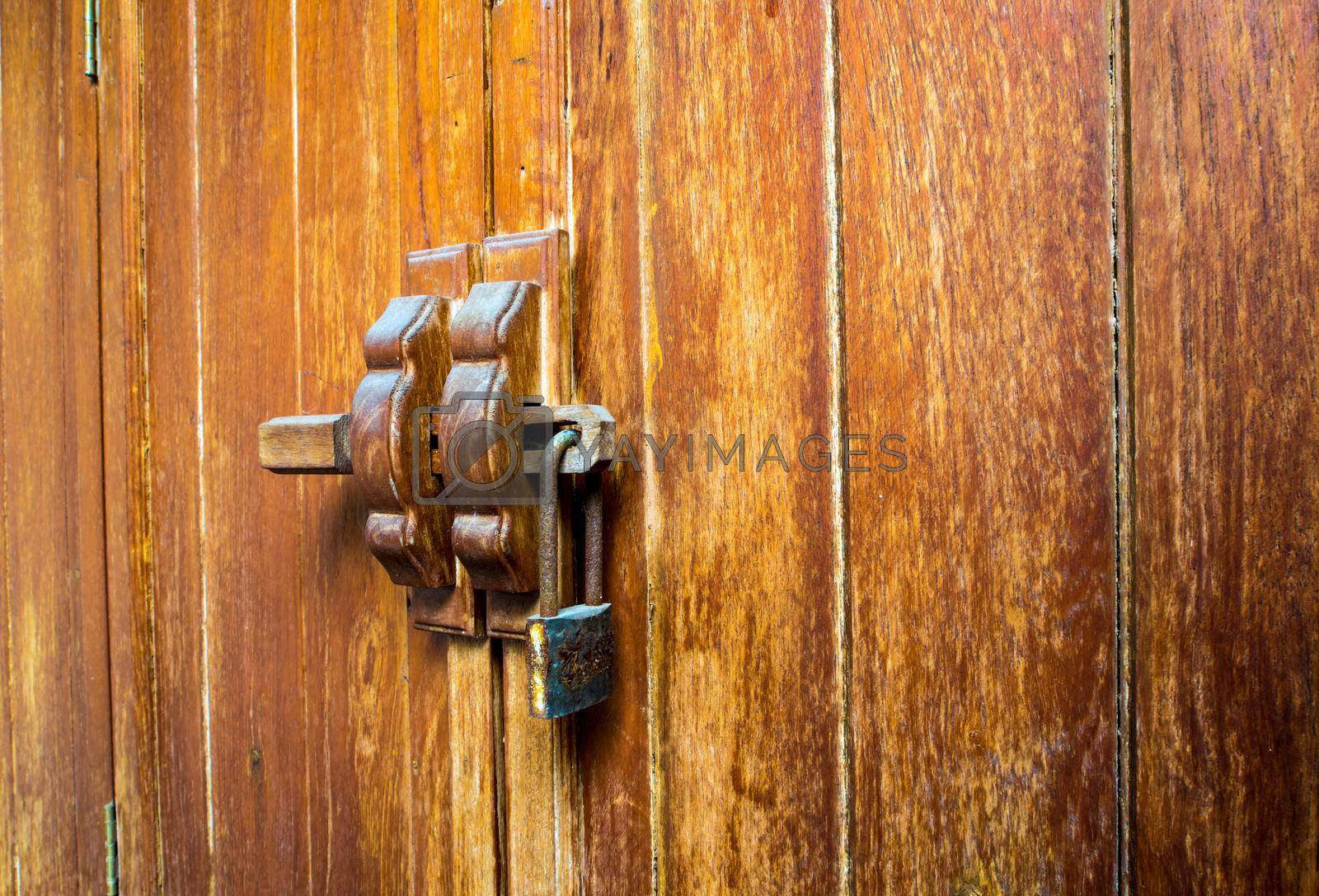 Royalty free image of Wooden cabinet and lock at the door handle by Satakorn