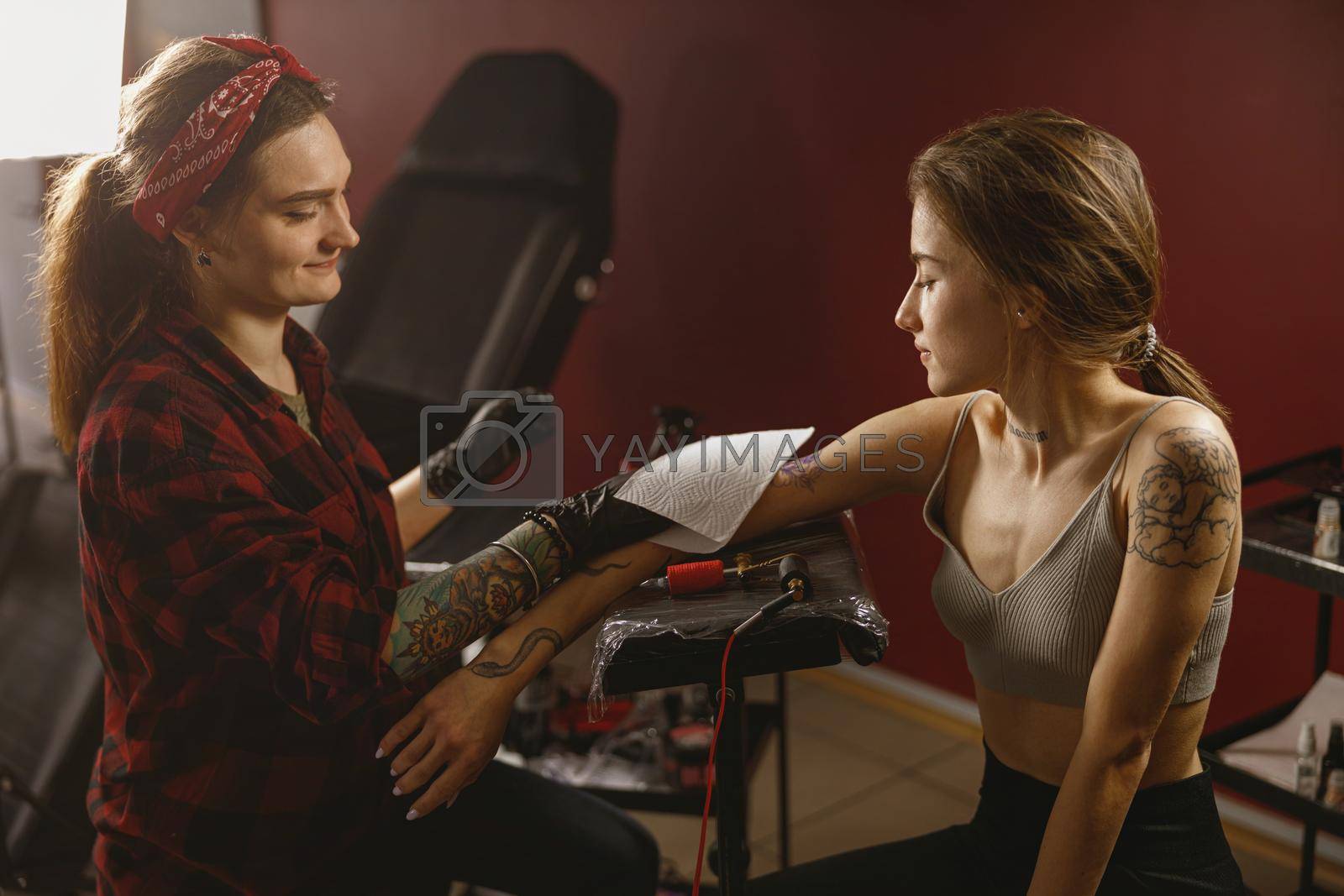 Royalty free image of Portrait tattoo artist and client sitting in tattoo parlor by Yaroslav_astakhov