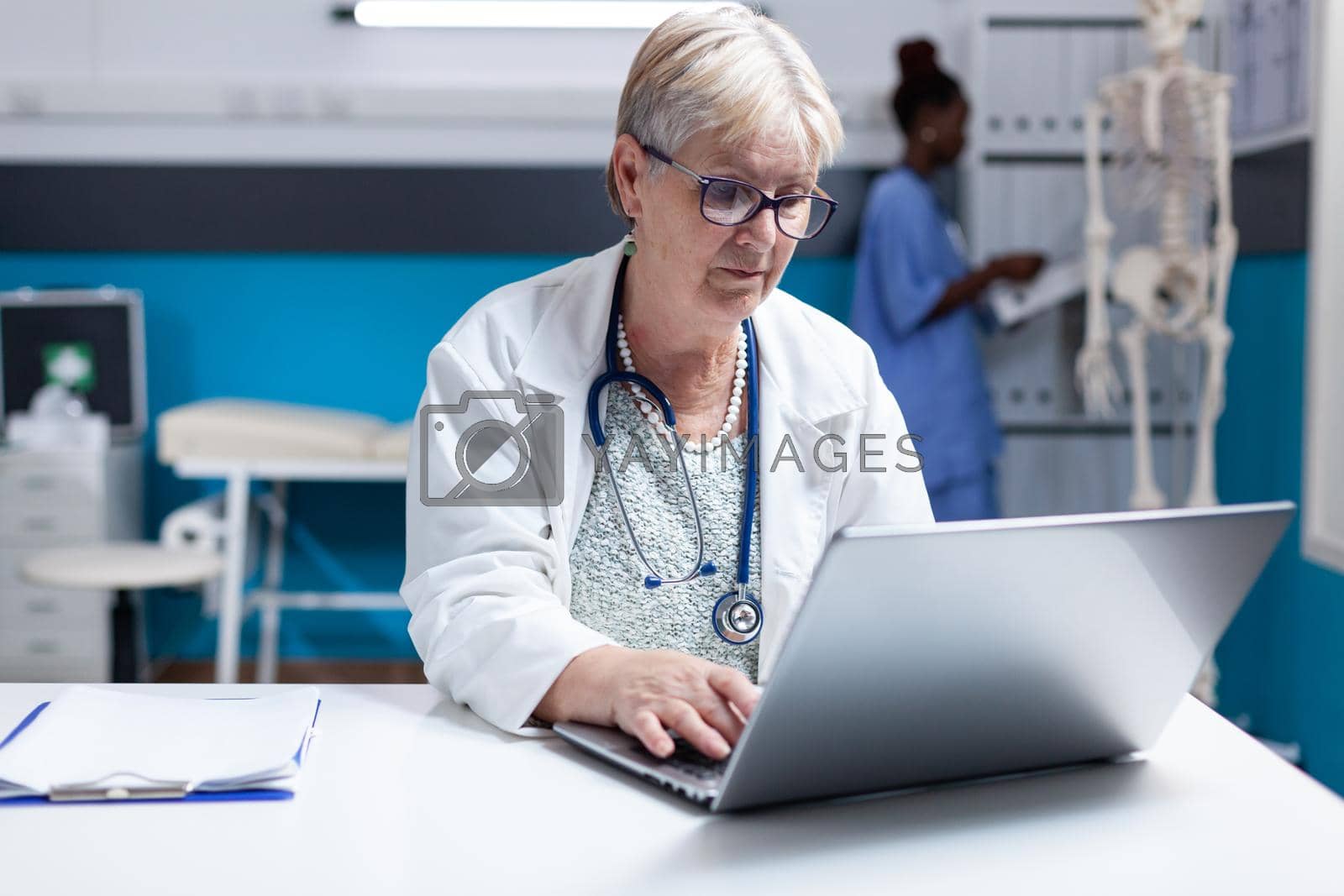 Portrait of medic with stethoscope using laptop to work on healthcare in cabinet. Woman doctor working with computer and technology to do prescription treatment analysis for examination.