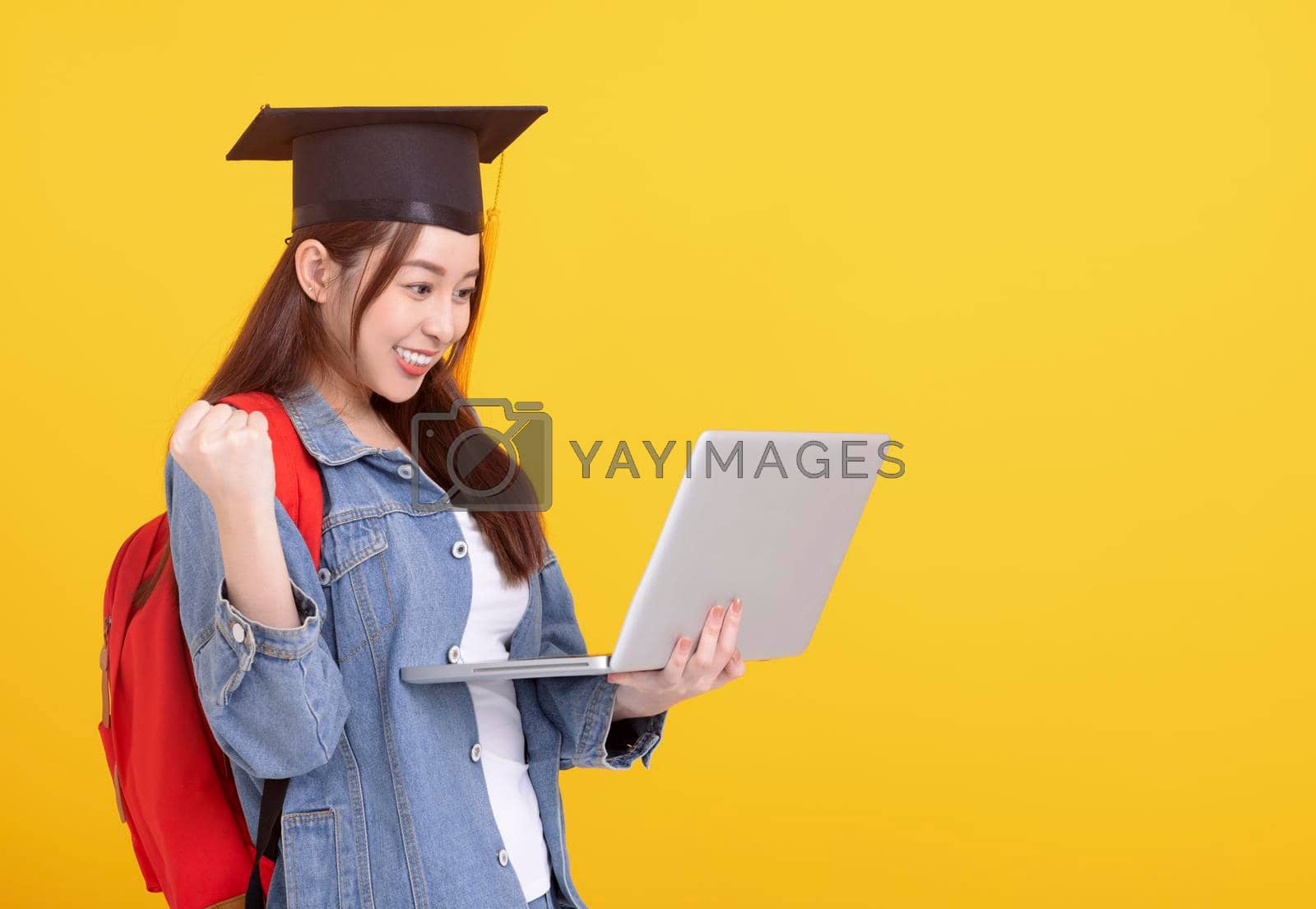 Royalty free image of Happy Asian girl college student in Graduation cap and holding laptop by tomwang