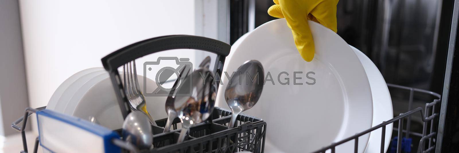 Royalty free image of Complete dishwasher with clean washed dishes closeup by kuprevich