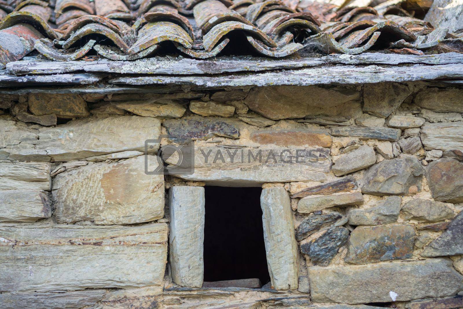 Royalty free image of Old stone window, slate roof and stone wall by FerradalFCG
