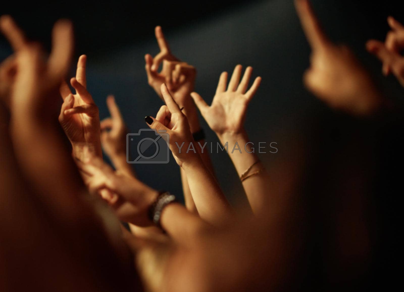 Royalty free image of Feeling the music. A crowd of people raising their arms to the music. by YuriArcurs