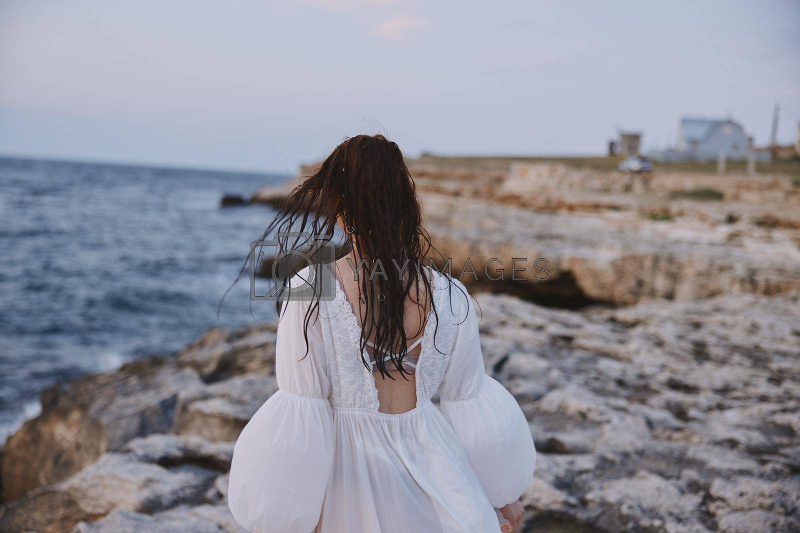 Woman in white dress summer walk ocean landscape travel. High quality photo