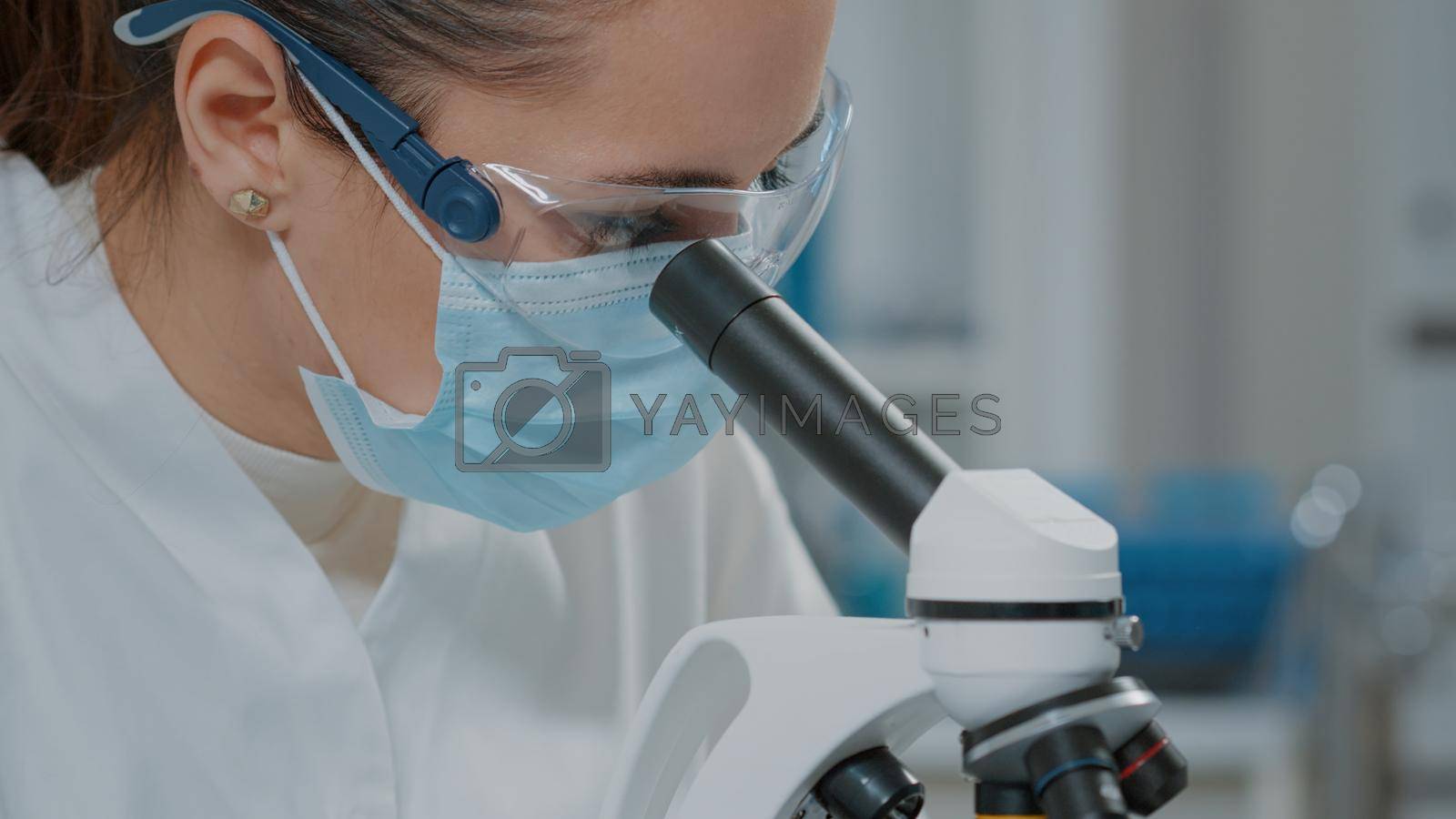 Royalty free image of Specialist analyzing dna on microscope in laboratory by DCStudio