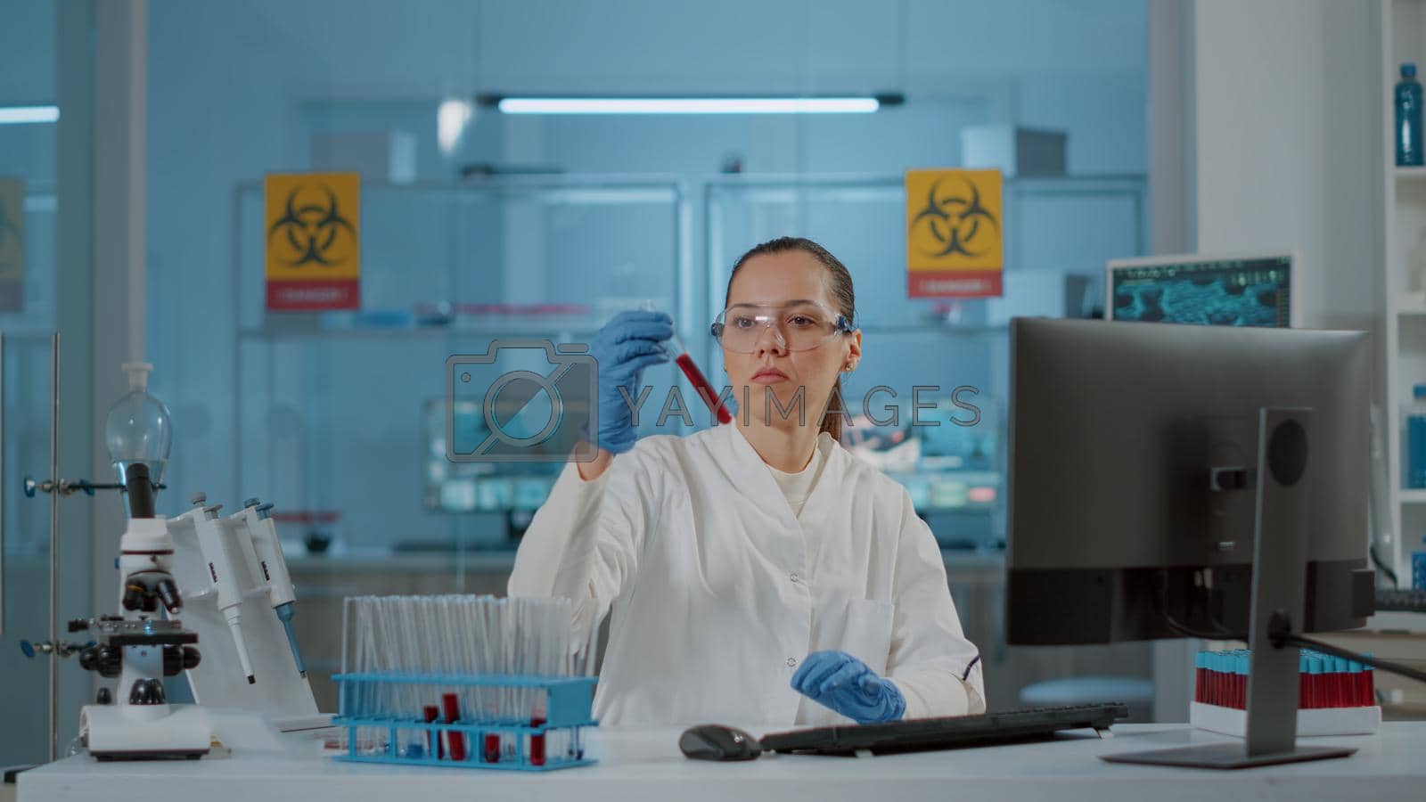 Royalty free image of Woman chemist analyzing substance in test tube for science by DCStudio