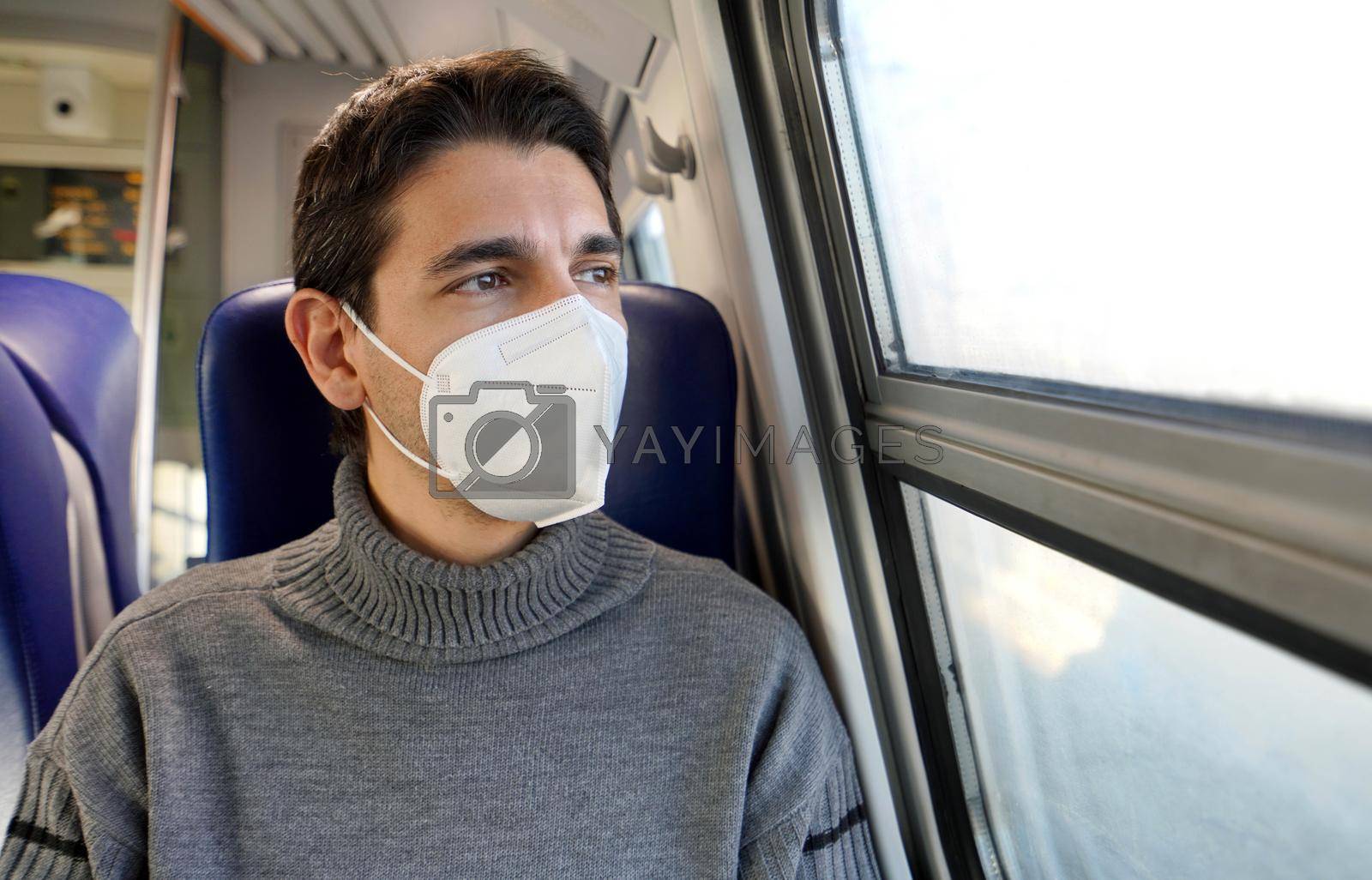 Close up of man looking through the window train wearing FFP2 KN95 protective face mask