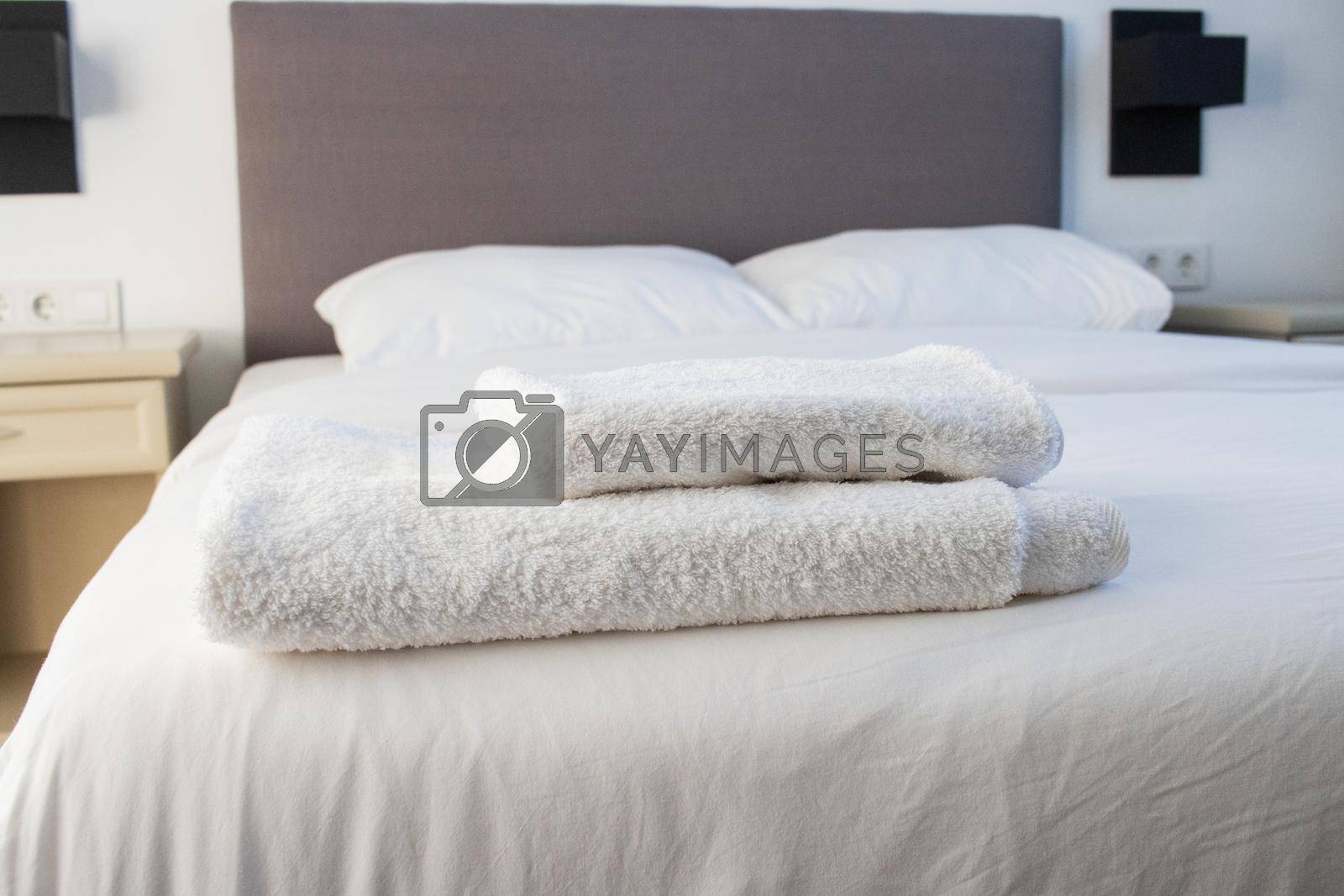 Royalty free image of White clean towels stacked on the hotel bed by senkaya