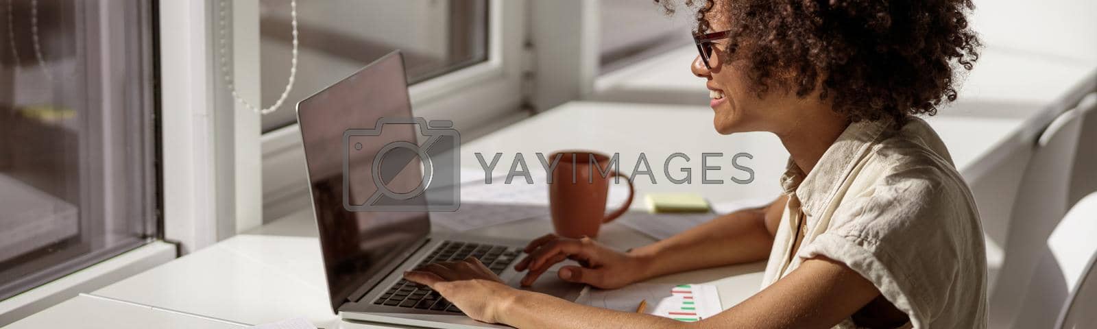 Royalty free image of African American woman concentrated looking at computer screen by Yaroslav_astakhov