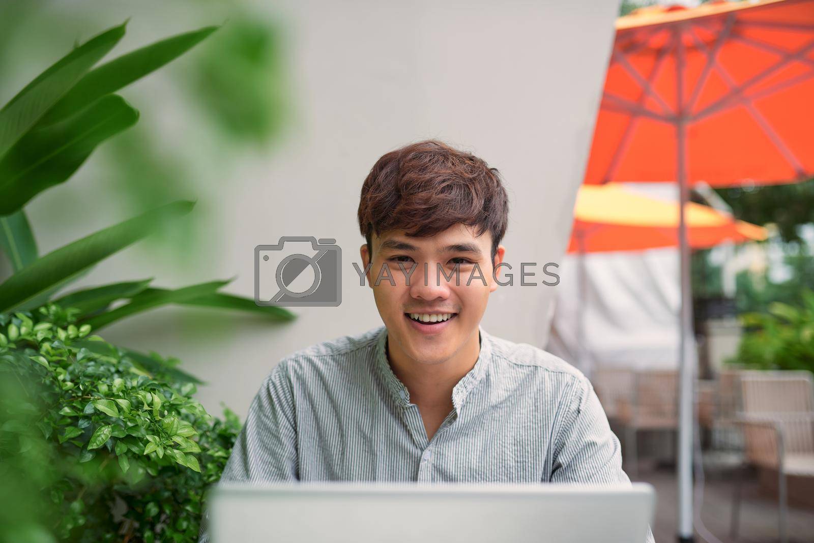 Royalty free image of Young freelancer working on laptop in coffee  by makidotvn