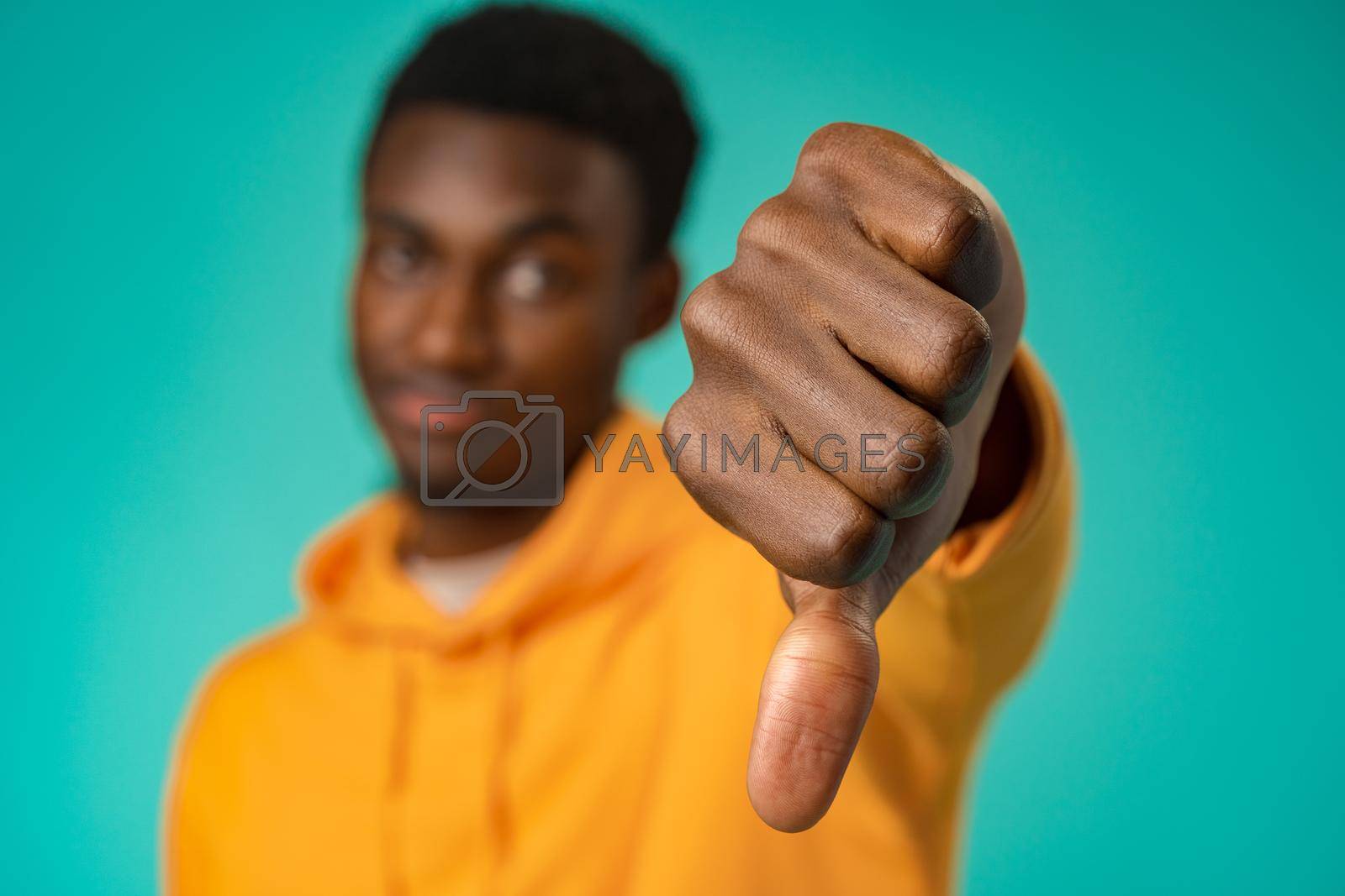 Royalty free image of Dissatisfied african american man show thumb down sign in studio by Fabrikasimf