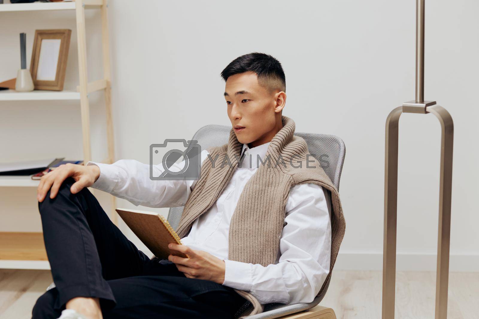 handsome man with a tablet sits in a chair communication technologies. High quality photo