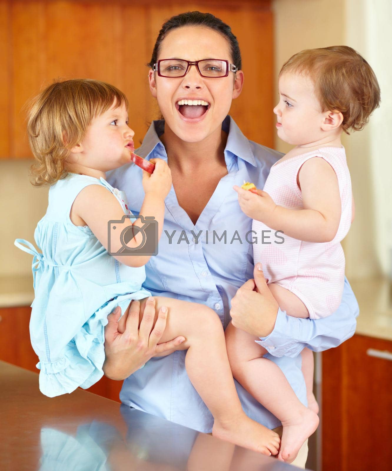 Royalty free image of Theyre a handful. Shot of a mother at her breaking point while cradling her two babies in her arms. by YuriArcurs