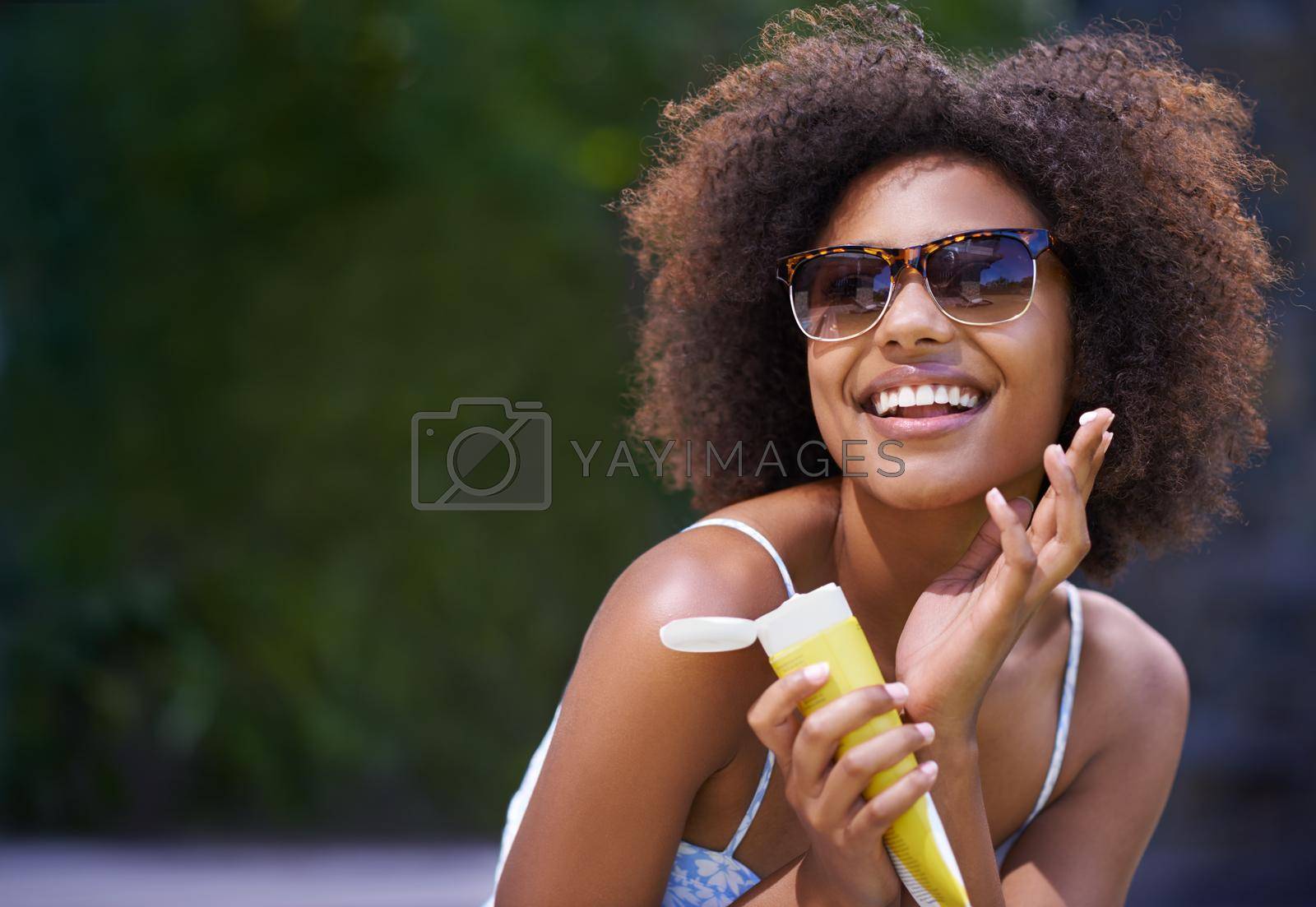 Royalty free image of I cant believe Im finally on holiday. Shot of an attractive female holding sunscreen. by YuriArcurs