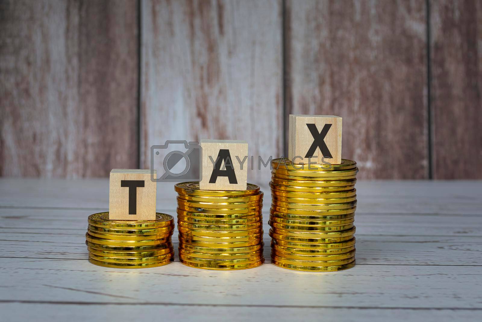Royalty free image of Tax text on wooden blocks and coins on table. Tax concept. by JennMiranda