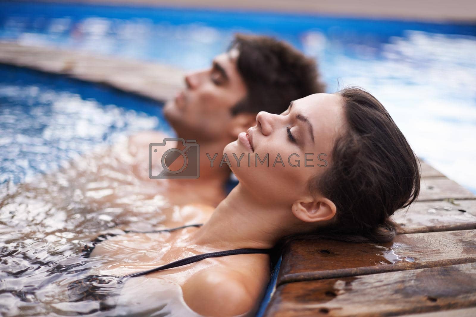 Royalty free image of Letting their minds drift. Shot of an attractive young couple relaxing in a pool. by YuriArcurs