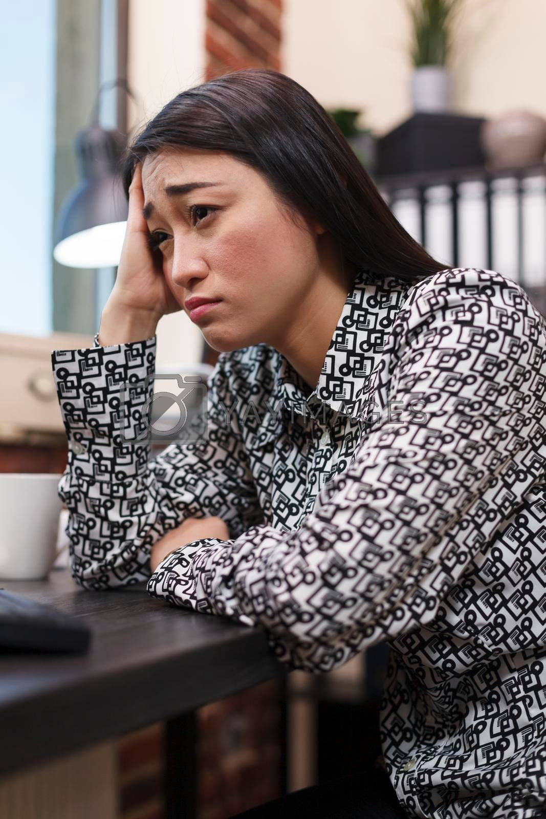 Marketing company frustrated worker stressed about business financial problems and poor management. Asian businesswoman worried about being fired while sitting at desk in financial office