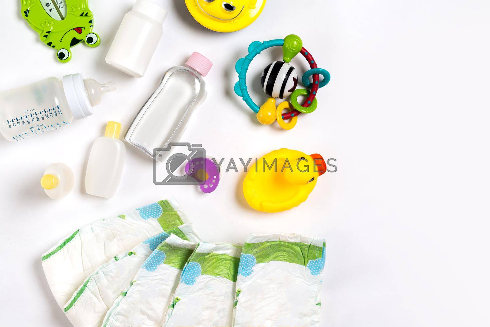 Babies goods diaper, baby powder, cream, shampoo, oil on white background with copy space. Top view or flat lay. Maternity concept