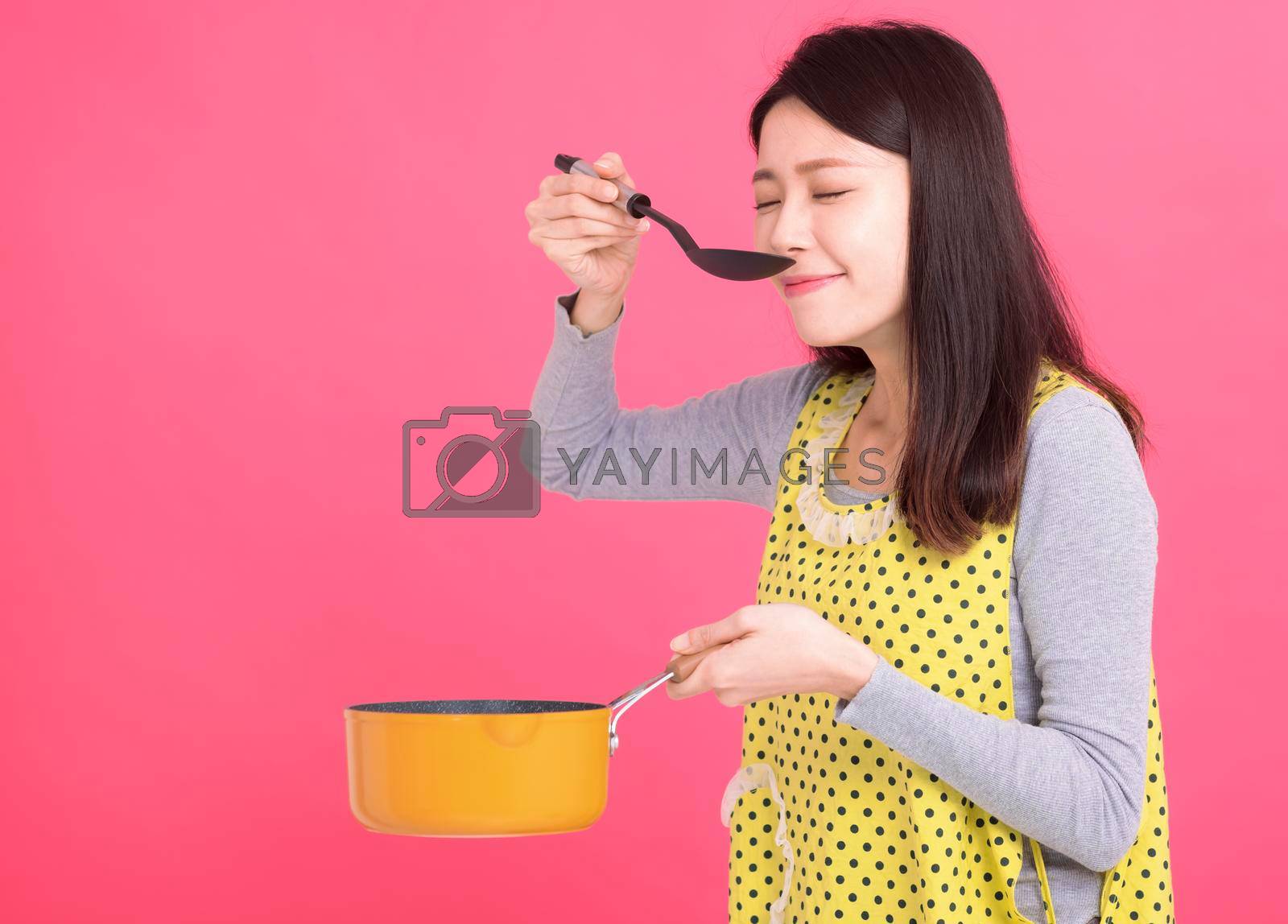 Royalty free image of young woman housewife Wearing Kitchen Apron while cooking by tomwang