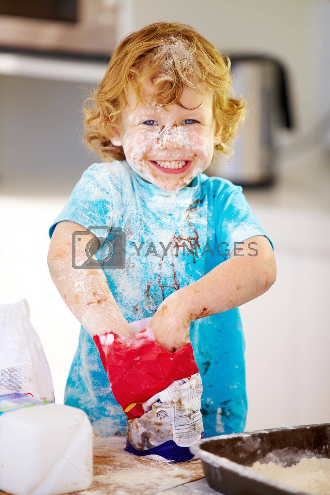 Royalty free image of The future of the culinary arts. A little boy covered in dough and flour. by YuriArcurs