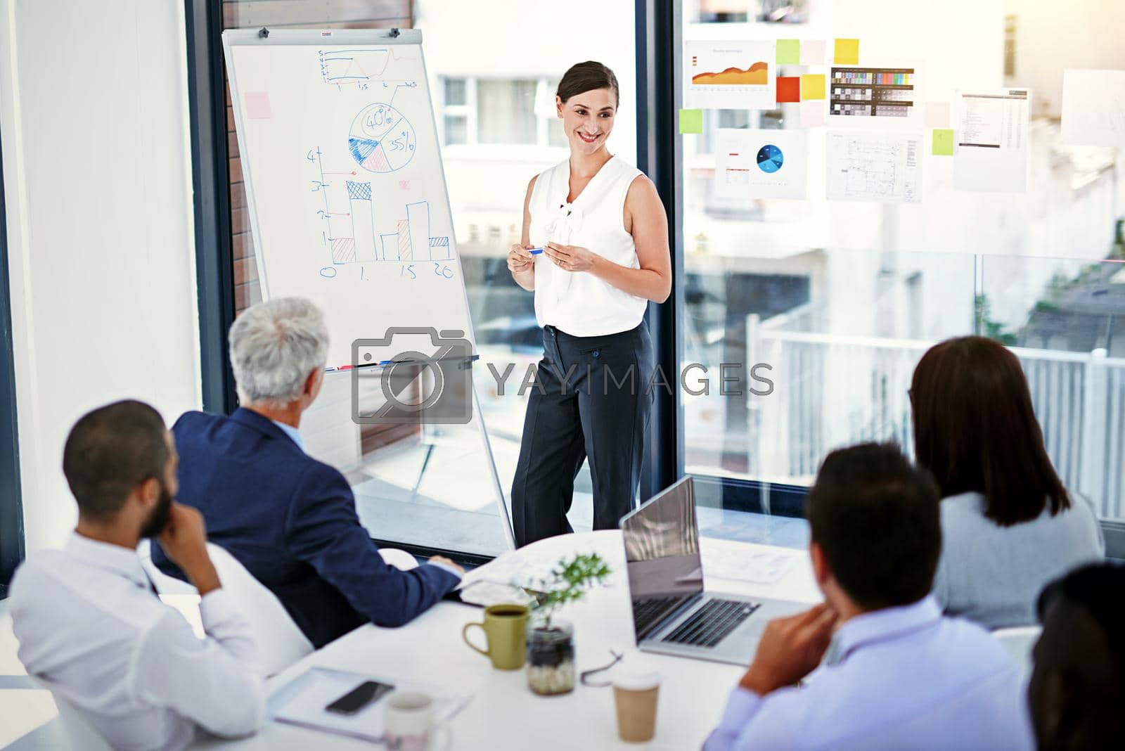 Royalty free image of Sharing her visions with the team. Shot of businesswoman giving a presentation to colleagues in an office. by YuriArcurs