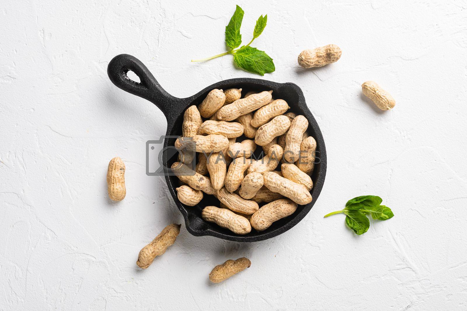 Royalty free image of Organic peanuts in shell, on white stone table background, top view flat lay by Ilianesolenyi