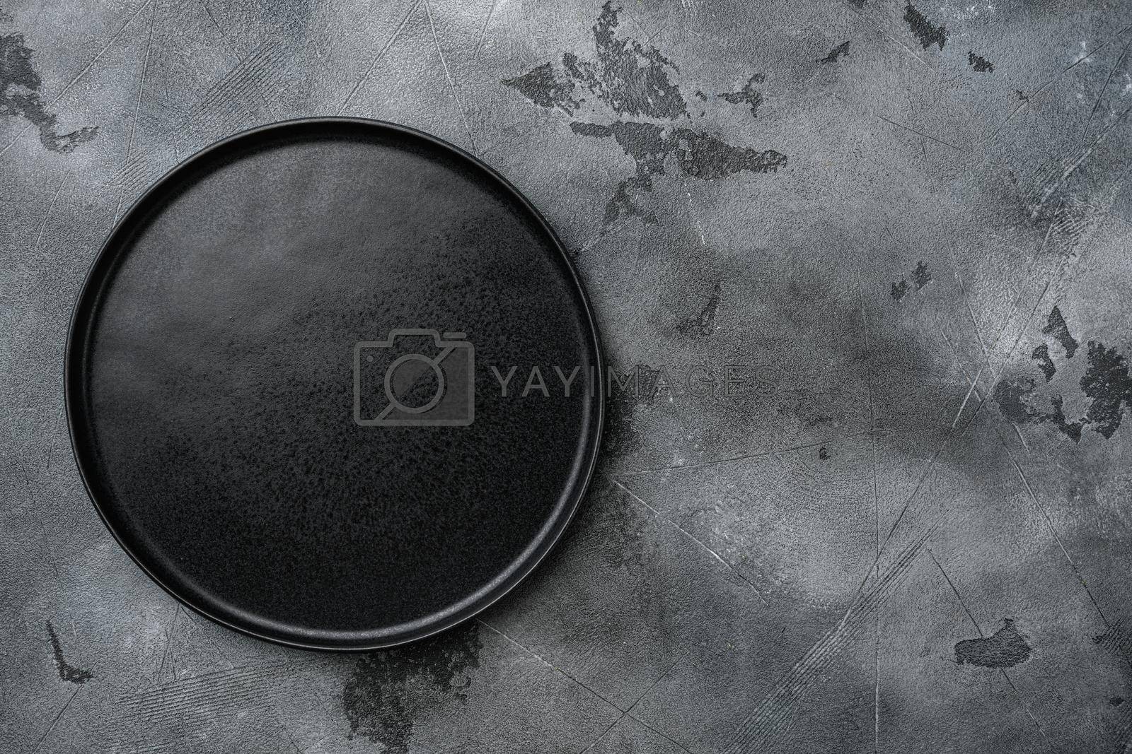Royalty free image of Empty black plate, on gray stone table background by Ilianesolenyi