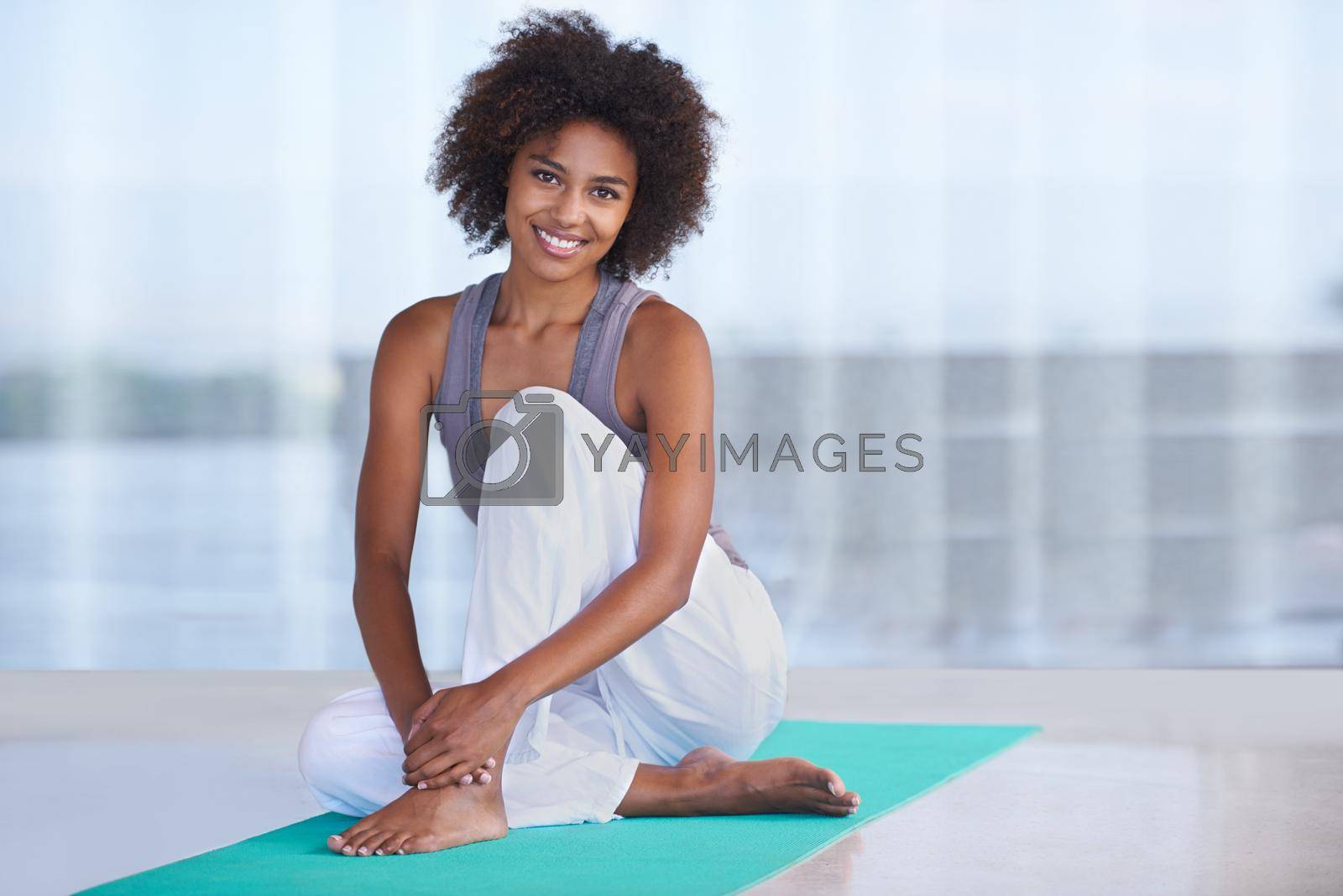 Royalty free image of Exercise makes me smile. Shot of an attractive young woman sitting on an exercise mat. by YuriArcurs