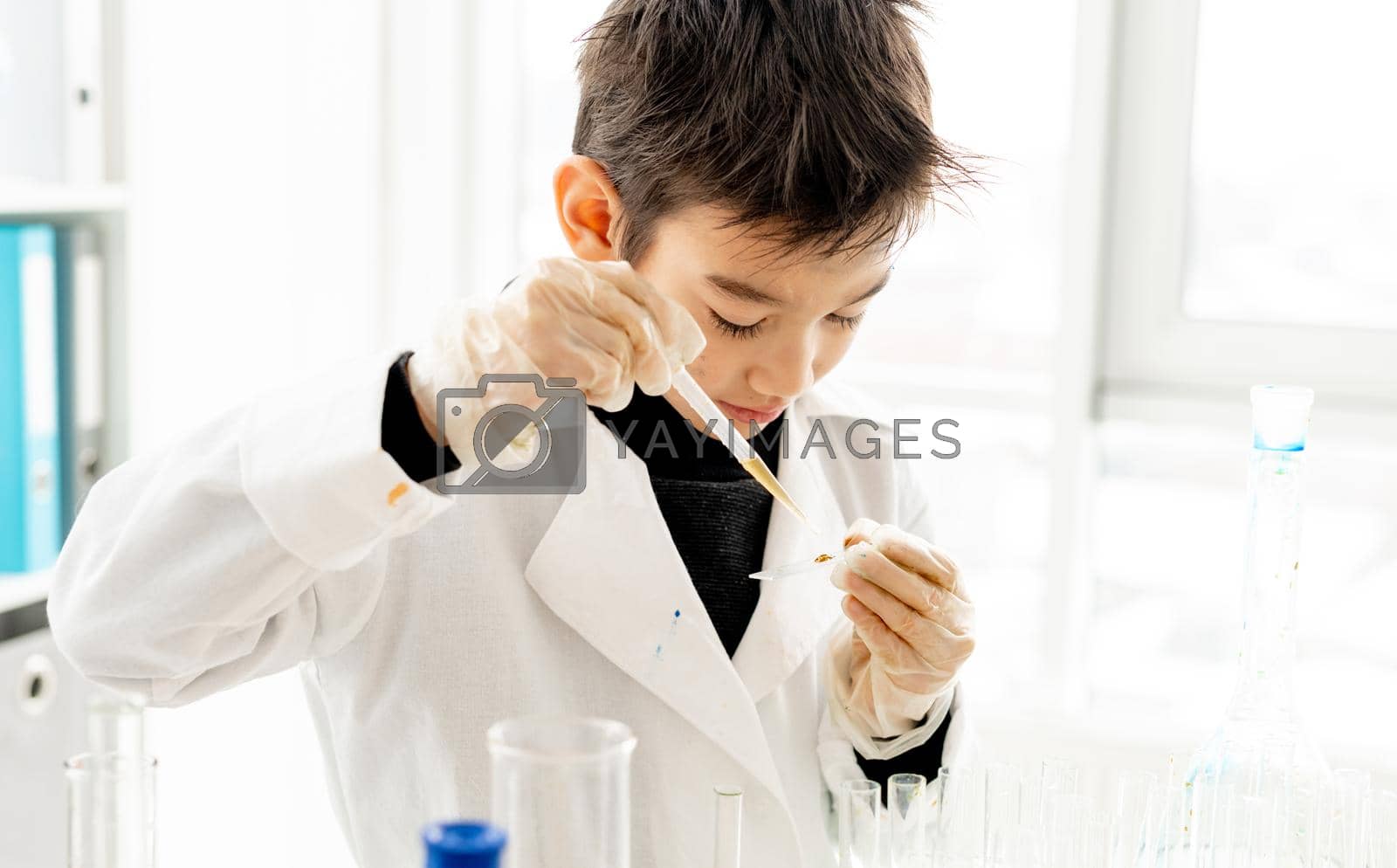 Royalty free image of School boy in chemistry class by tan4ikk1