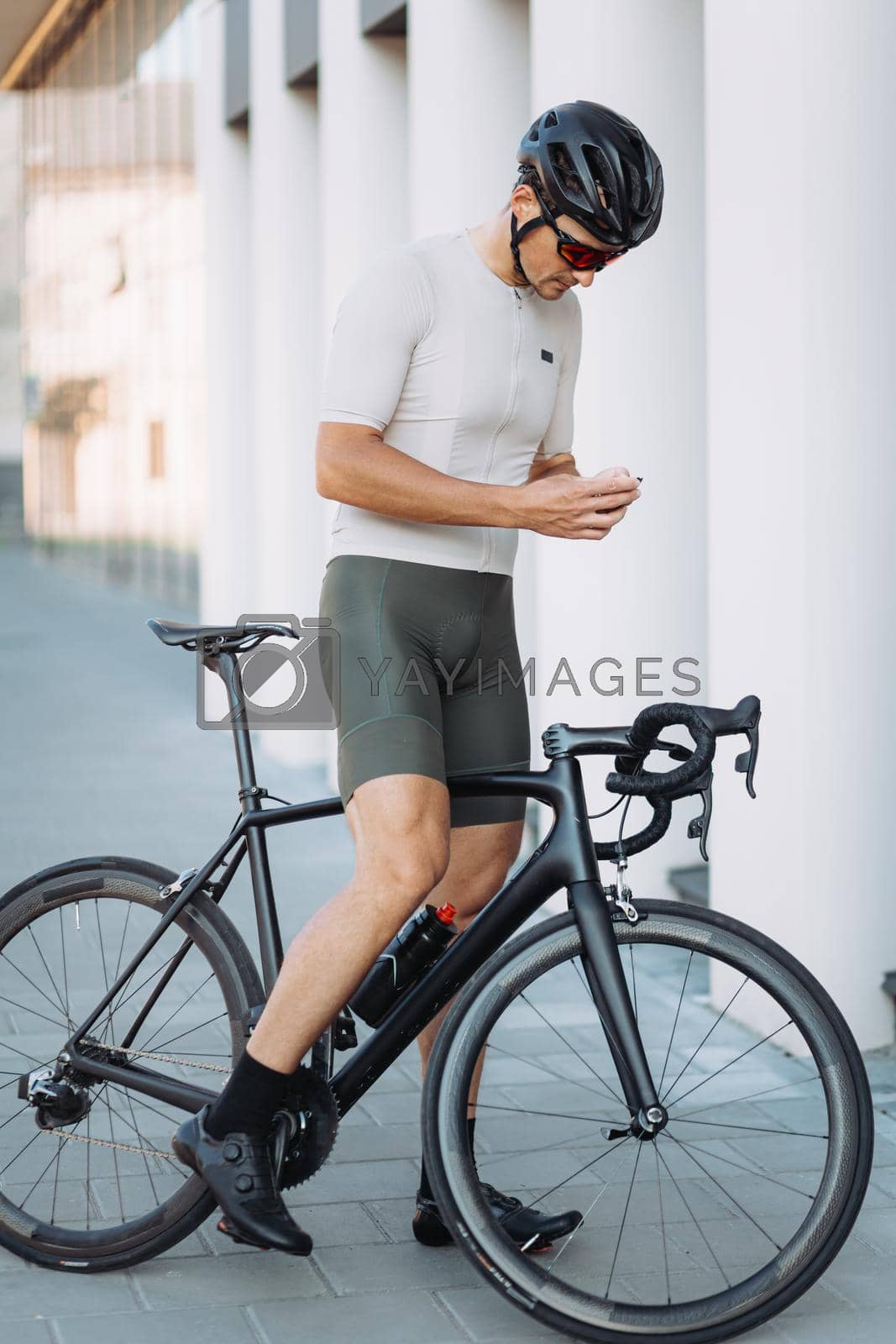 Royalty free image of Cyclist standing with bike and holding modern navigator by Tymoshchuk