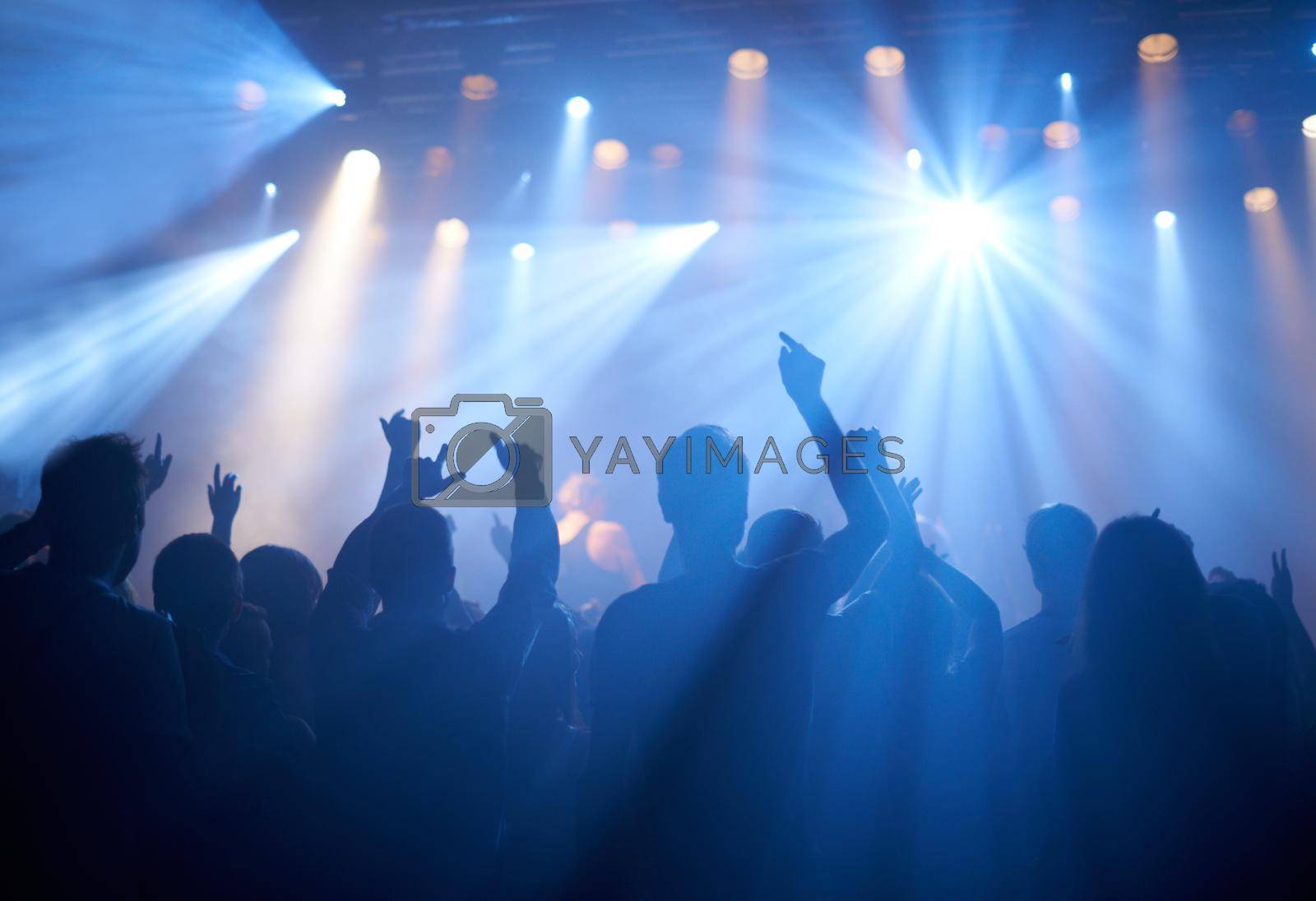 Royalty free image of Cheering on their favourite band. Shot of adoring fans at a rock concert. by YuriArcurs