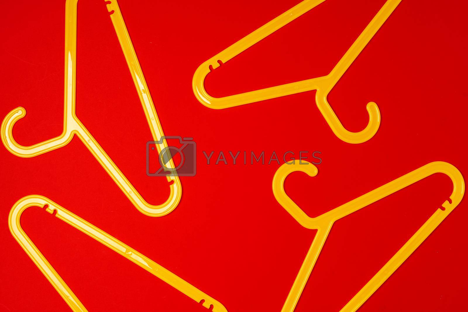 Hanger on red paper background. Minimalistic fashion concept.