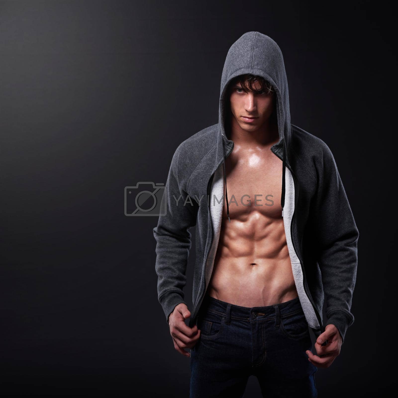 Royalty free image of Strength above all else. Studio shot of a handsome bare-chested young athlete standing against a black background. by YuriArcurs