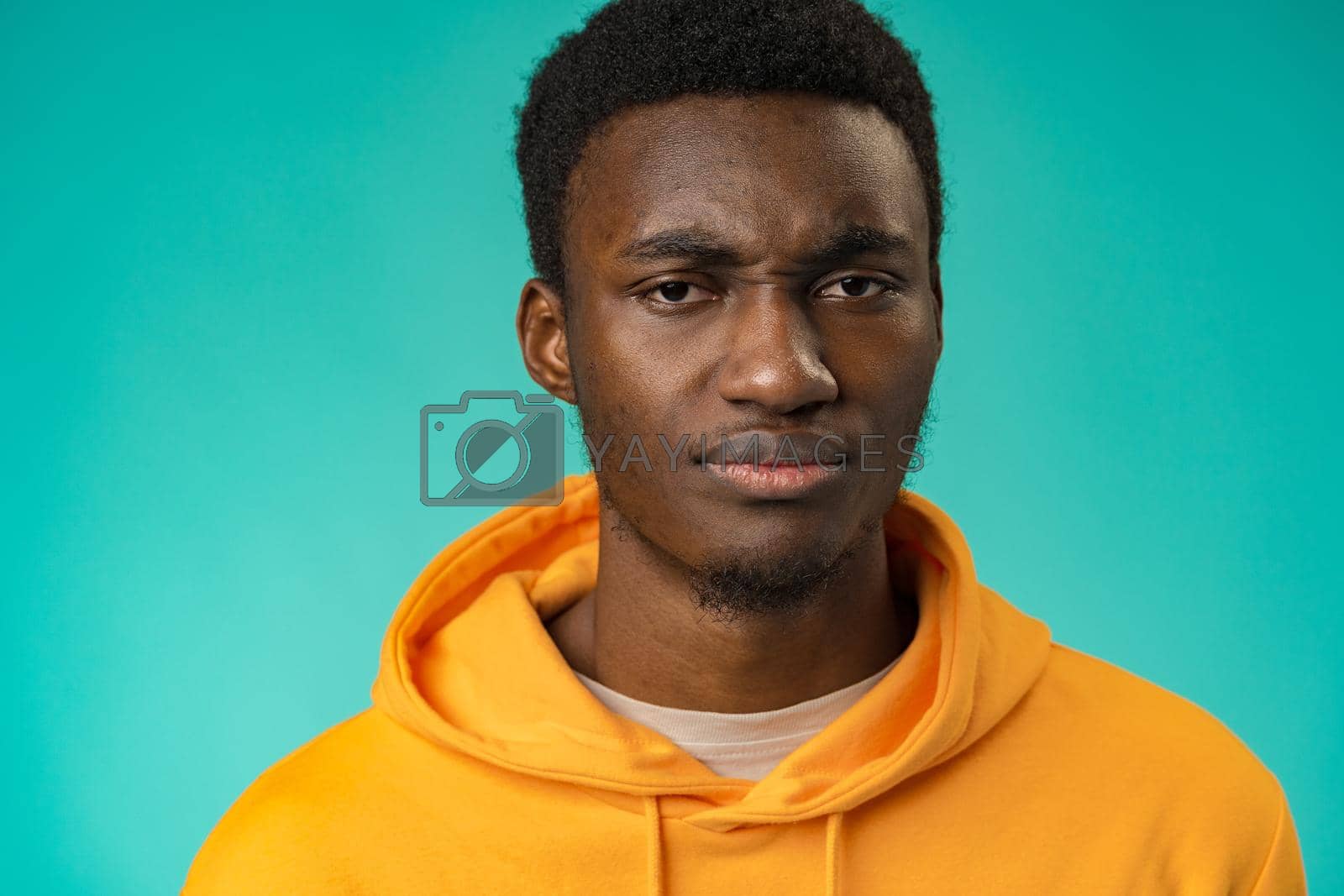 Royalty free image of Portrait of young handsome afro-american guy sadly looking at camera in studio by Fabrikasimf