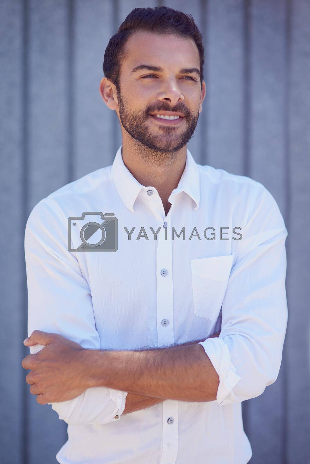 Royalty free image of Happiness looks good on him. Shot of a well-dressed young man posing outside. by YuriArcurs