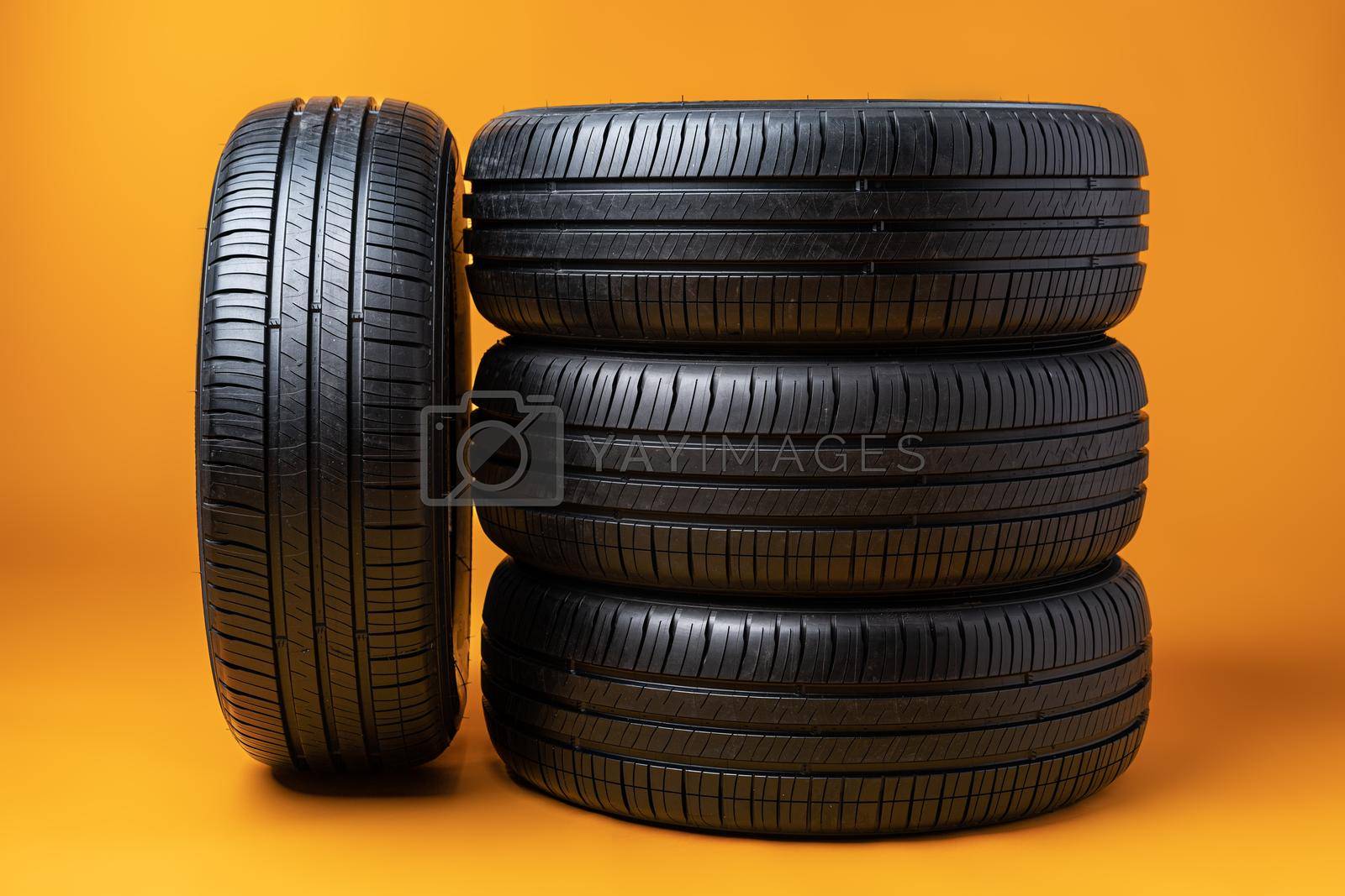 Royalty free image of Car tires isolated on yellow background, close up by Fabrikasimf