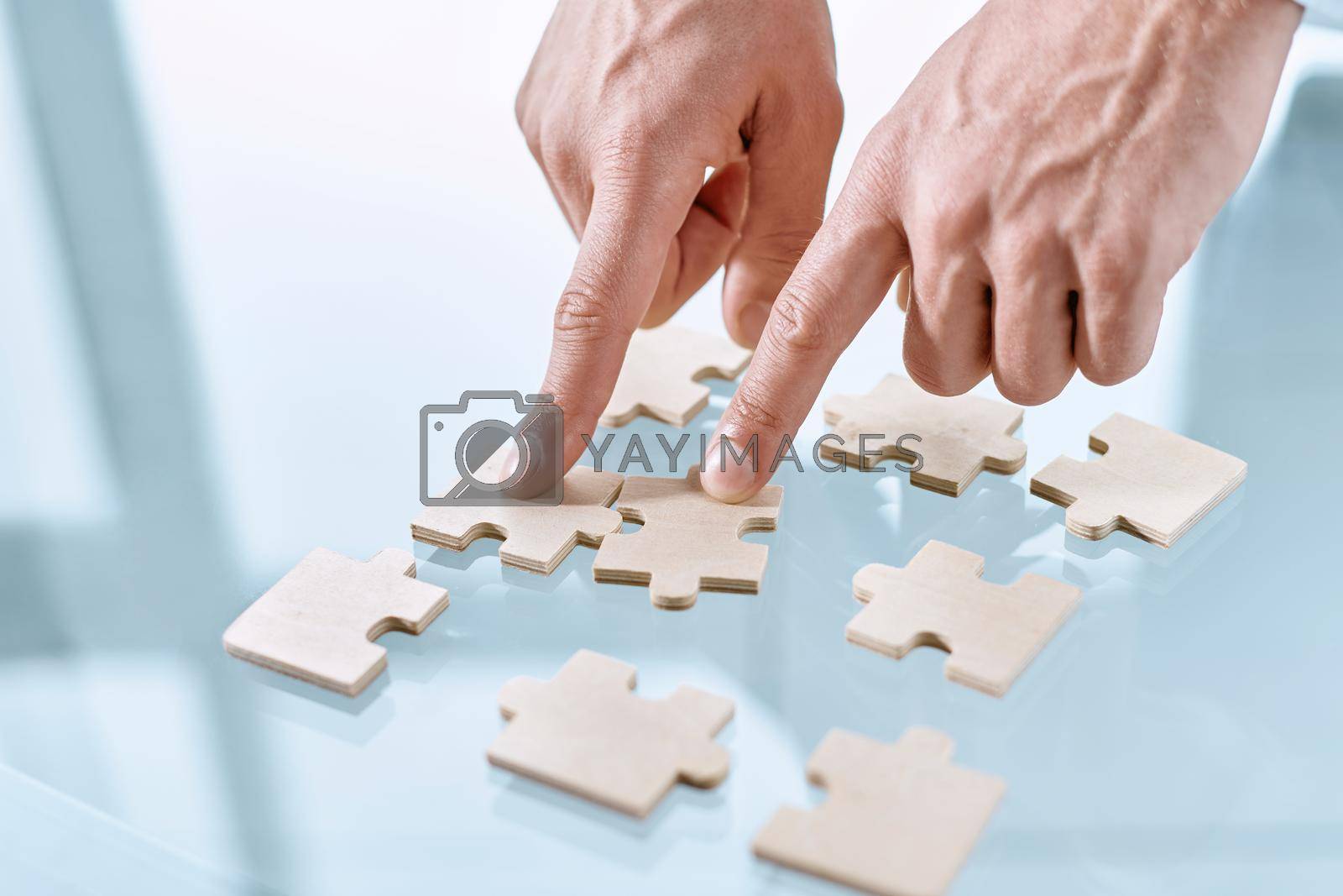 close-up. businessman starting to assemble a puzzle . bottom view. business concept.