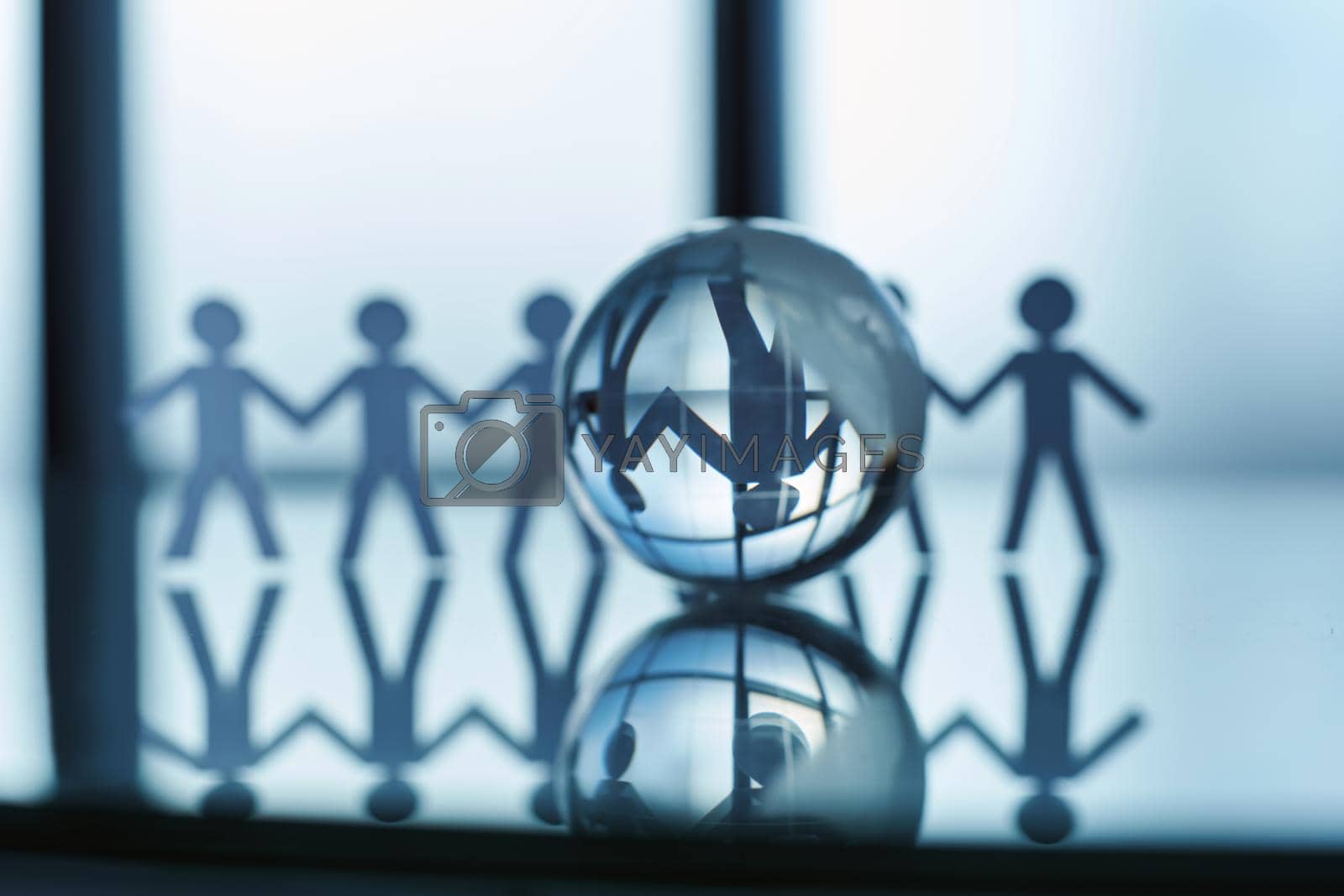 glass globe and a paper business team on an office background . business concept.