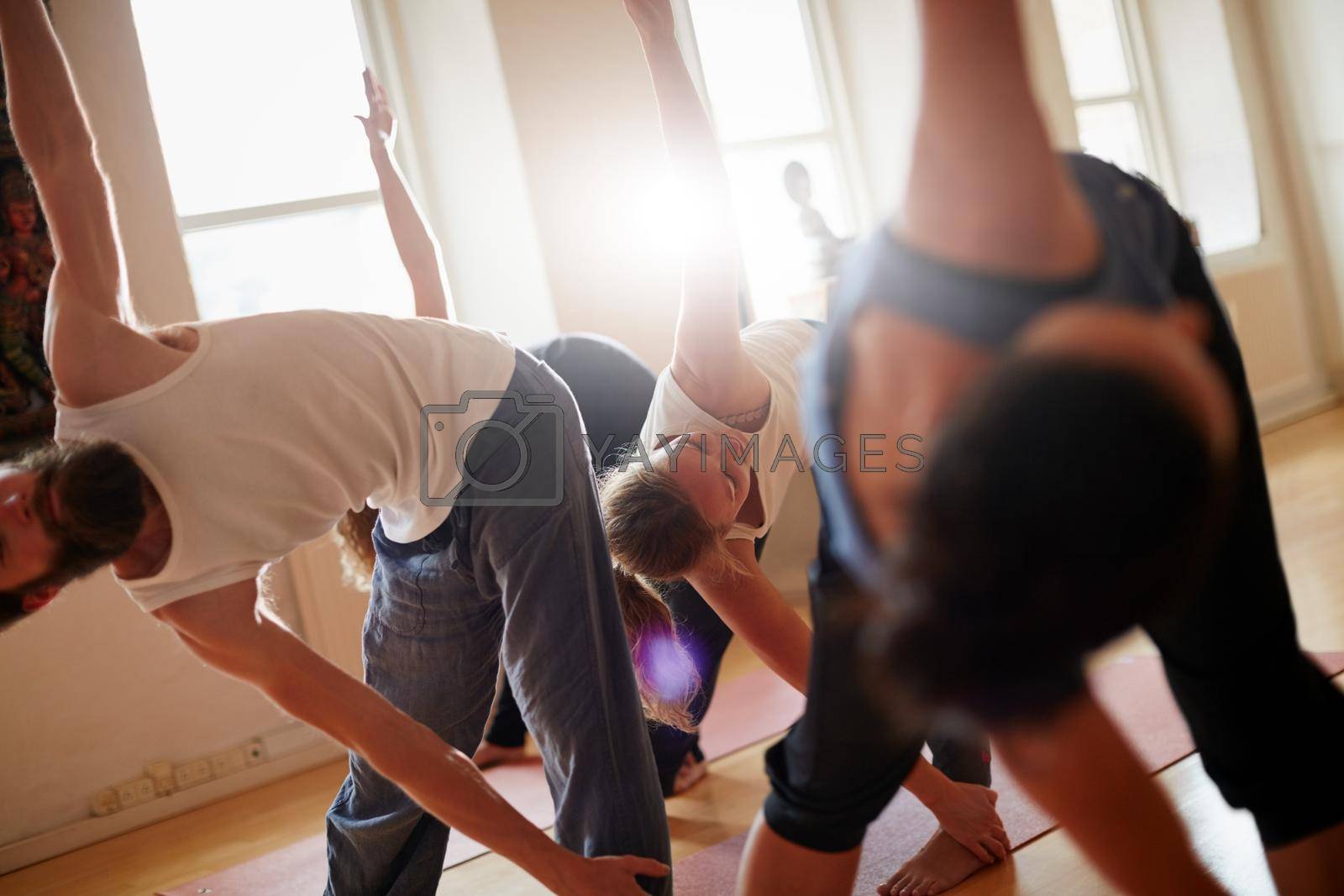 Cropped shot of a group of people attending a yoga class.