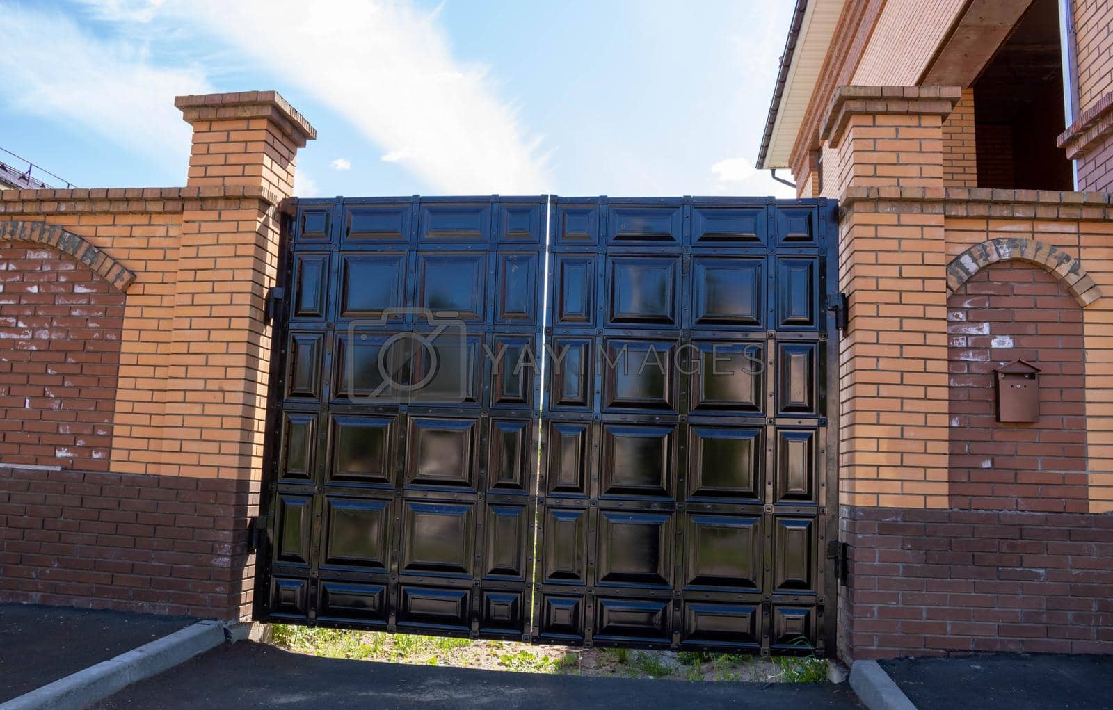 Royalty free image of New forged metal double gates for entry of cars into the yard closed by lapushka62