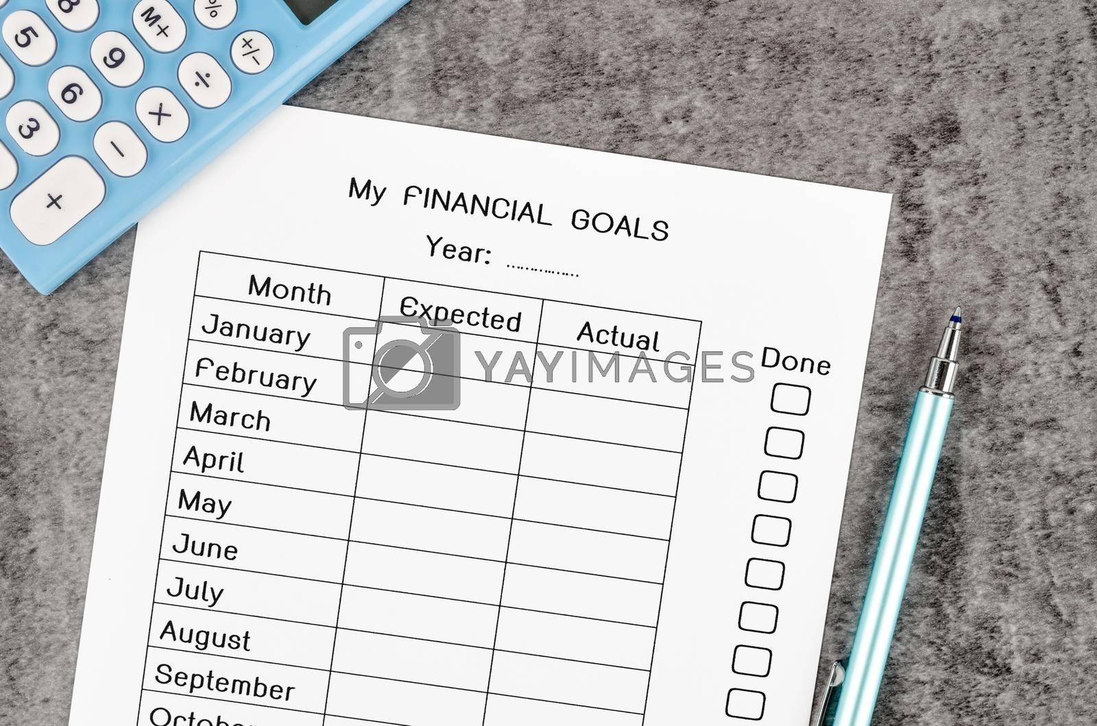 My planning financial goals form and pen with calculator on wooden background.